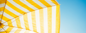 yellow and white umbrella with a blue sky