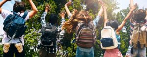 kids jumping with backpacks on