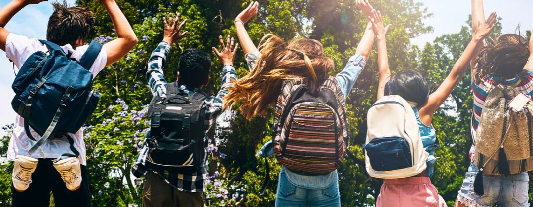 kids jumping with backpacks on