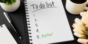 desk top with note pad that reads "to do list with numbers 1-5. #5 says Retire"