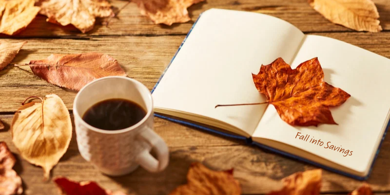 cup of coffee with fall leaves and an open notebook that reads "fall ino savings"