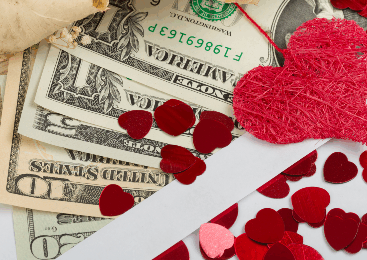 money on a table with valentines hearts.