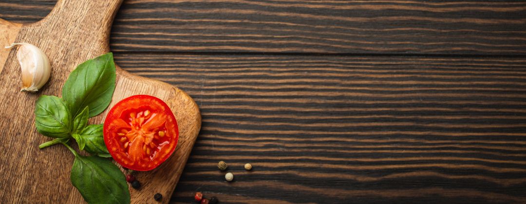 cutting board with tomato, basil and garlic